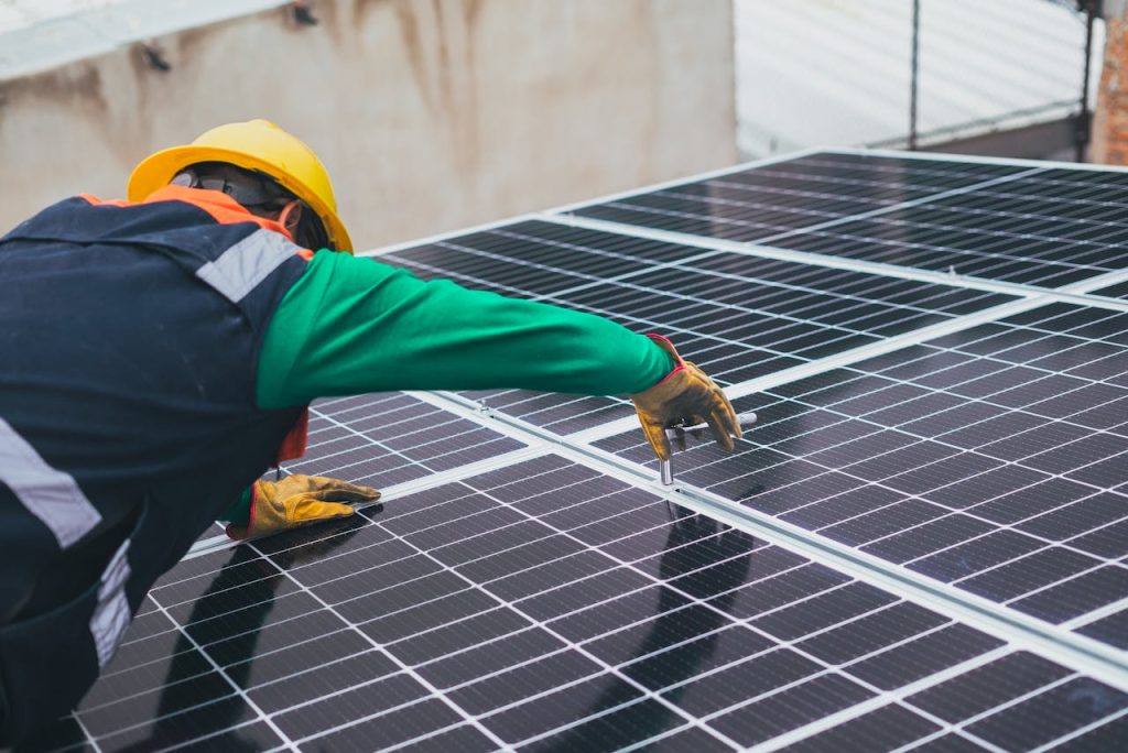 pexels-photo-8853502 Technician installing solar panels on a rooftop for sustainable energy solutions.